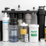 Ein modernes Umkehrosmose-Wasserfiltersystem, das in einer Küche installiert ist, mit einem Glas kristallklarem Wasser auf der Theke